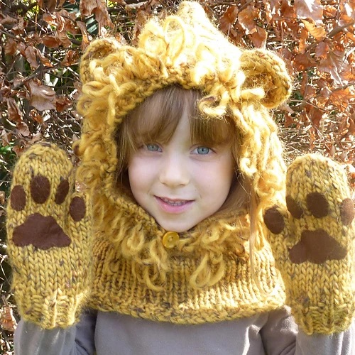 Child wearing a knit cowl hood  resembling a lion and lion paw mittens