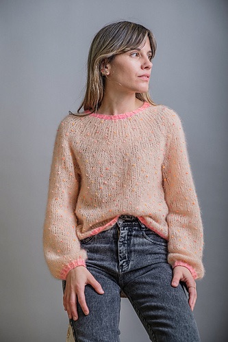 Person wearing a pink, beaded knit sweater