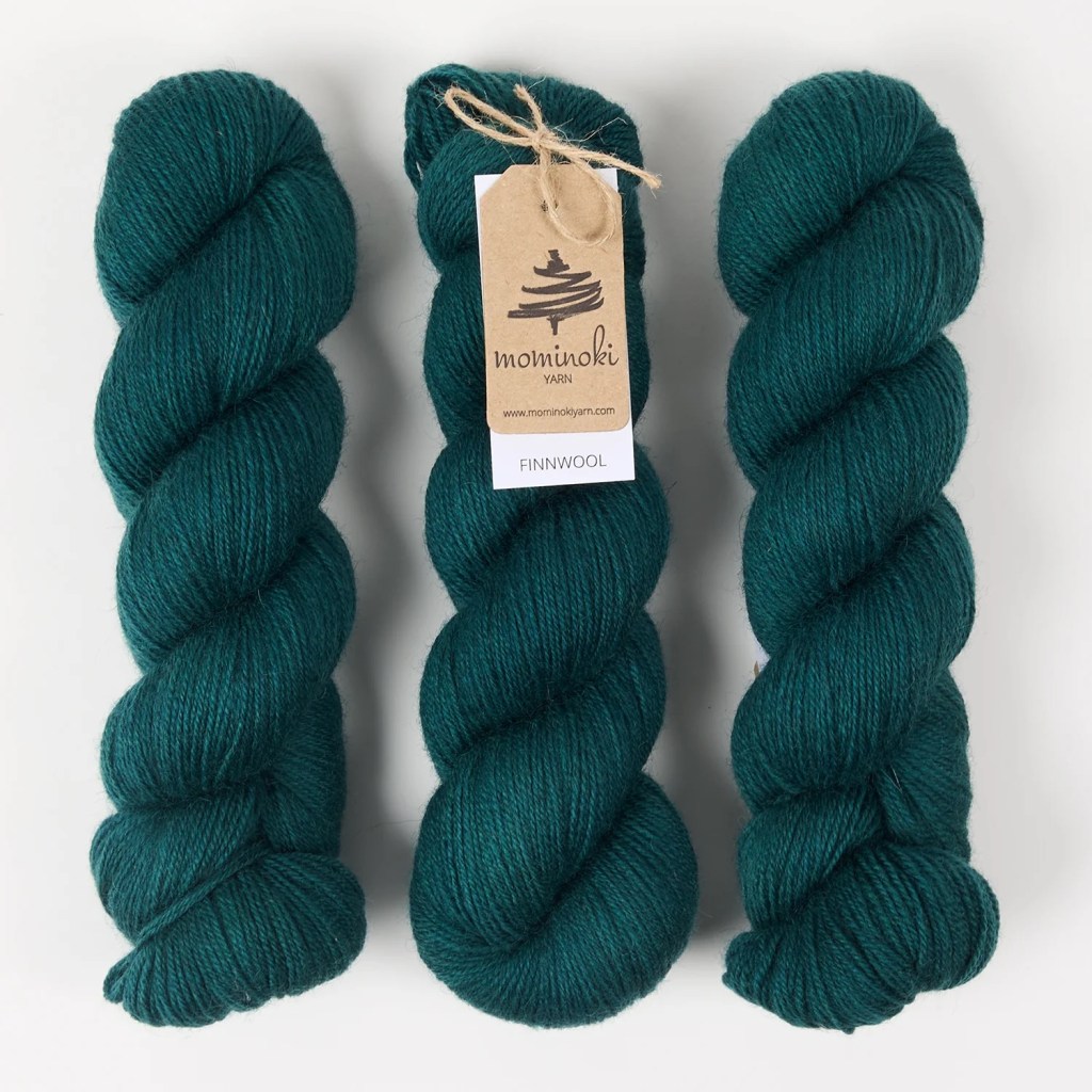 Three skeins of finnwool yarn in evergreen colorway