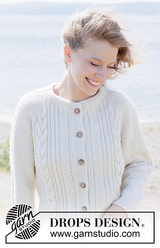 Person wearing a white cabled cardigan