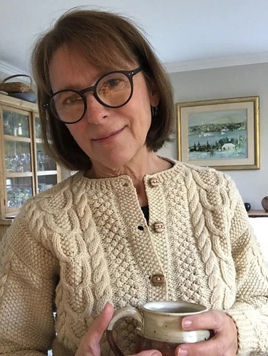 Person wearing a cream cabled cardigan 