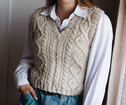 Person in a white cabled knitted vest