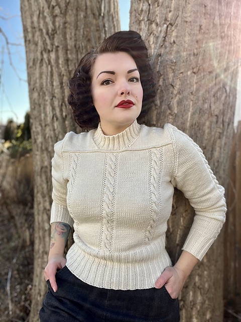 Person wearing a white cabled sweater