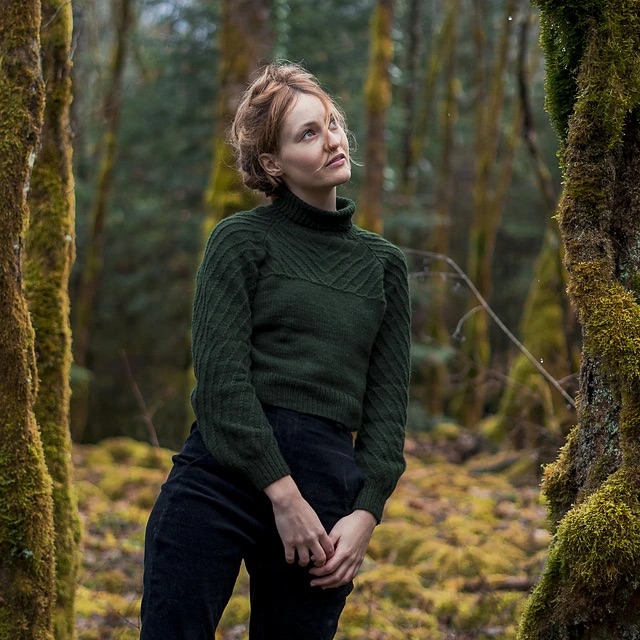 person wearing a green textured turtleneck sweater 