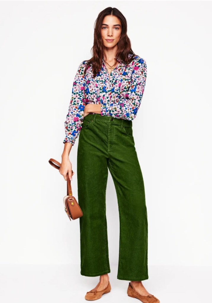 Person wearing a flowered top and green corduroy pants