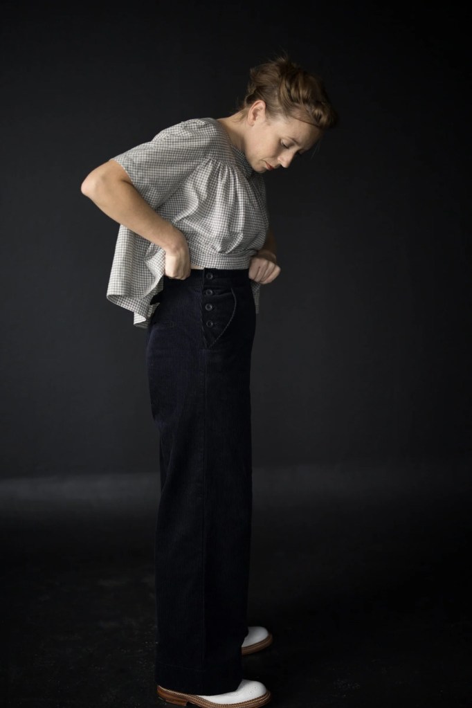Person wearing high waisted trousers with a button placket